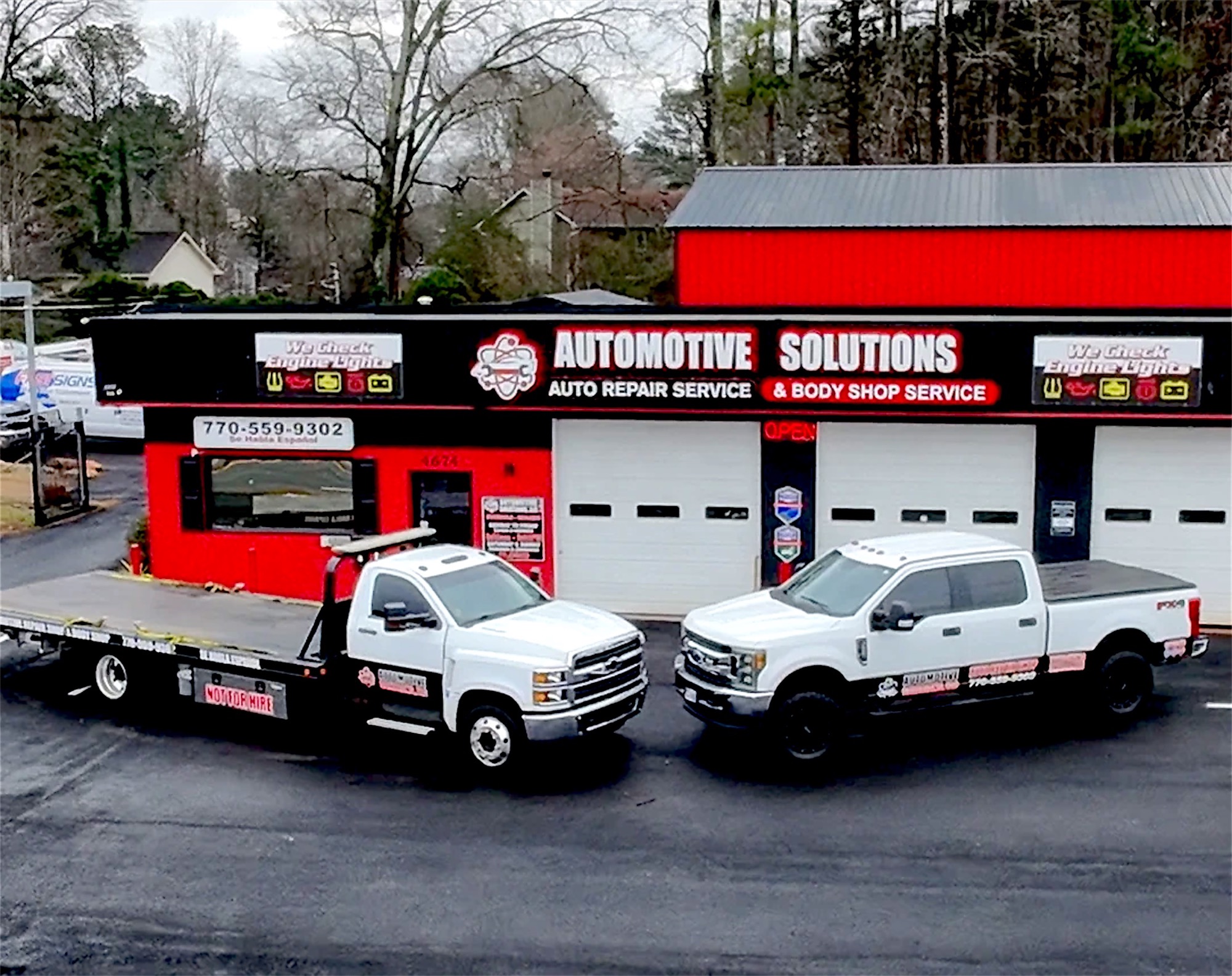 The Automotive Solutions flatbed tow truck and service truck parked in front of the shop on Stone Mountain Highway, Lilburn
