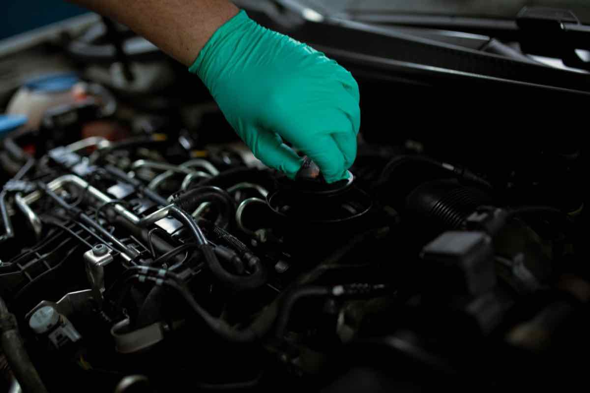 An oil change underway on the lift at Automotive Solutions